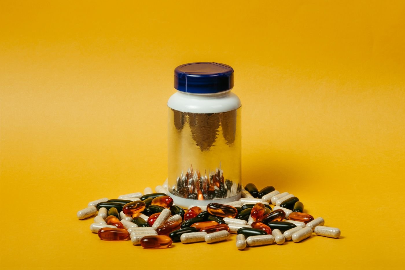 Assorted vitamin and supplement capsules arranged on a clean, bright surface